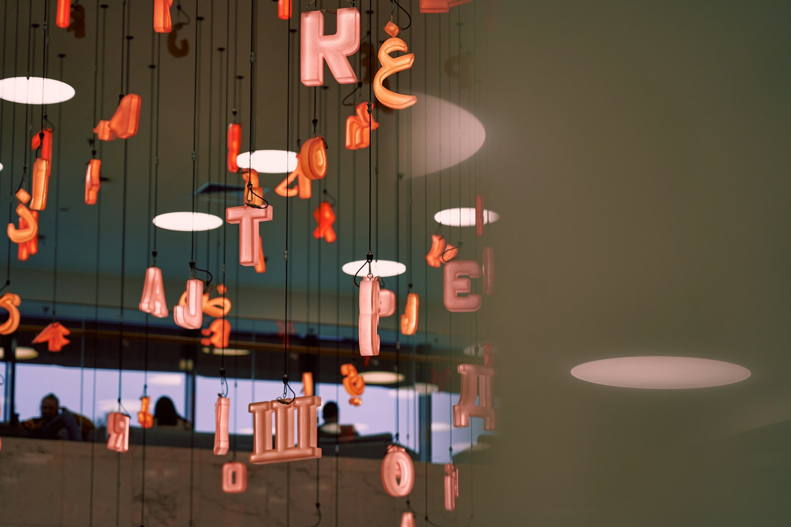 a group of people sitting at a table with food from the ceiling